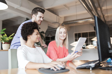 happy creative team with computer in office