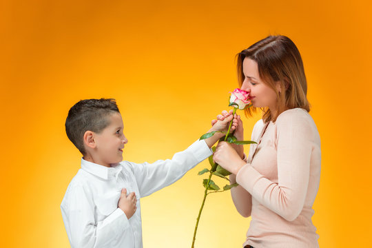 Young Kid Giving Red Rose To His Mom