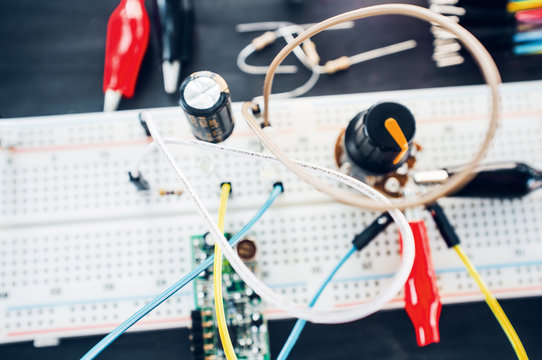 Experiment with electronic components close-up. Breadboard with wires and connectors. Students experience in laboratory.