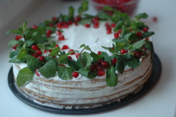 Sponge cake with white cream, mint and berries pomegranate.