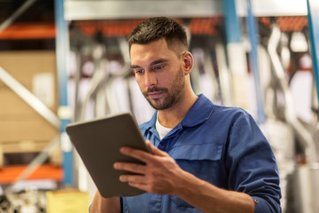 auto mechanic or smith with tablet pc at workshop