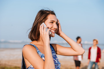 Happy woman talking on mobile phone outdoors