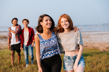 Two cheerful young men and women laughing outdoors