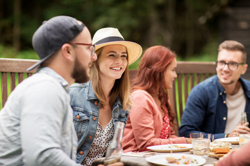 happy friends having dinner at summer garden party