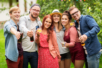 happy friends with drinks at summer garden party