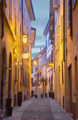Fototapeta na wymiar CREMONA, ITALY - MAY 24, 2016: The street of old town in morning dusk.