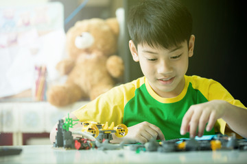 Cute asian boy playing with plastic blocks