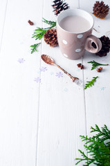 Fototapeta na wymiar vintage Cup of hot cocoa on wooden background decorated with spruce and pine cones,