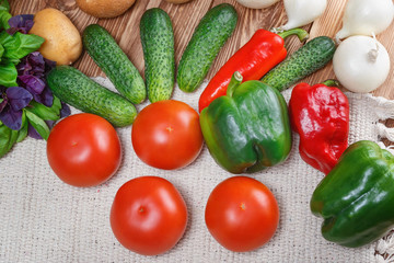 Fototapeta na wymiar Vegetables on a wooden table..Potatoes, onions, cucumbers, peppers, tomatoes, basil.