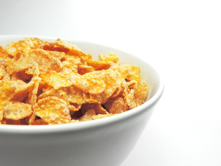 cornflakes in a white bowl, isolated on white background.
