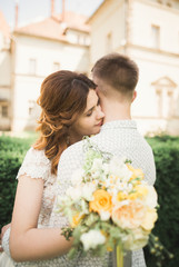 Beautiful fairytale newlywed couple hugging near old medieval castle