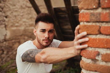 Attractive guy next to a brick wall