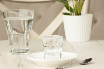 empty glasses and a spoon on a white table with a flower