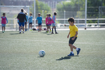 Naklejka premium Niño en un entrenamiento de fútbol 7, deportes de equipo para actividades extraescolares