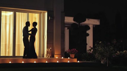 WS Silhouette of couple dancing on patio at night / India