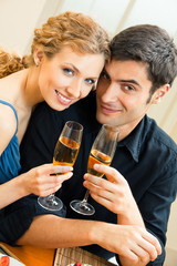 Young couple celebrating with champagne at home. Love, relations, romantic concept shoot.