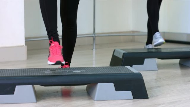 Step Aerobic girl. Foots. Slow motion. Young women in an aerobics class

