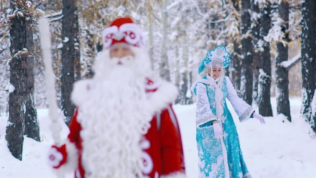 Ded Moroz Father Frost and Snegurochka Snow Maiden walking in the forest and having fun at the new year Eve