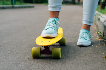 Close-up of female legs in blue jeans and sneakers standing on a