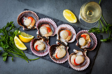 Raw scallops with lemon, cilantro on slate plate, white wine