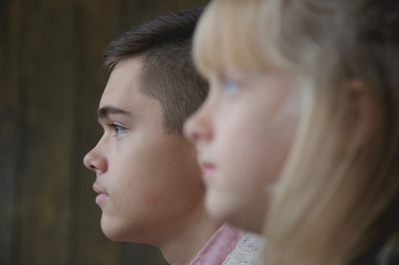 Fototapeta premium Profiles of young brother and little sister. Shallow depth of field, focus on boy.