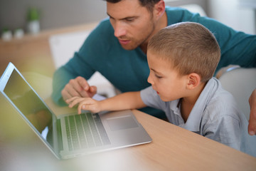 Daddy with kid using laptop computer for e-learning