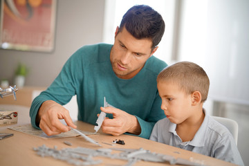 Father and son building up model together