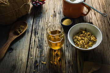 Focus Spot Chrysanthemum Tea and dried chrysanthemum on an old wooden table. Chrysanthemum blossoms are a type of herbal plants. In the morning, drink chrysanthemum Tea will make you feel refreshed. 