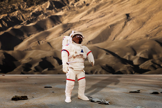 astronaut wearing pressure suit in a sand dune background