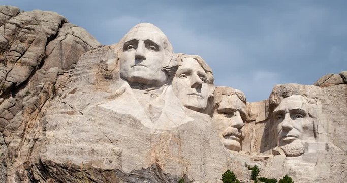 Mount Rushmore National Memorial, South Dakota, USA - granite sculpture Mount Rushmore with moving clouds, sunlight and shadows - Timelapse with zoom out 