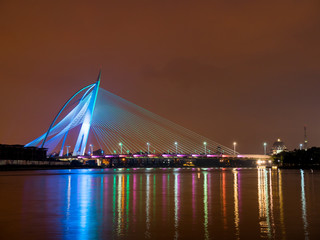 Blue colour lighted Seri Wawasan Bridge with reflection on the water at Putrajaya, Malaysia