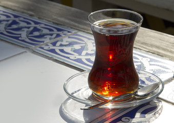 Traditional turkish glass of tea on the old wooden table
