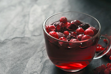 Cup of tea with berries on the dark stone table horizontal