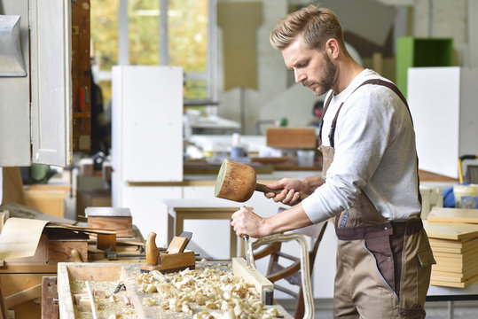 Carpenter working with mortise chisel in workshop