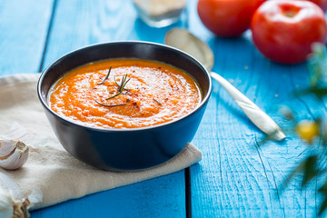 Fresh Hot Tomato Soup in a Bowl on Blue Wooden Background, Horizontal View