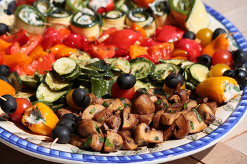 vegetarische Antipasti ( kalte Vorspeisen) mit u.a. tomaten, pilzen, oliven, zuchini, knoblauch, paprika, oregano auf einem Teller