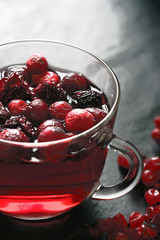 Cup of tea with berries on the dark stone table