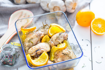 Homemade Chicken Thighs with Rosemary and Oranges in Baking Dish on White Wooden Table using for Wallpaper