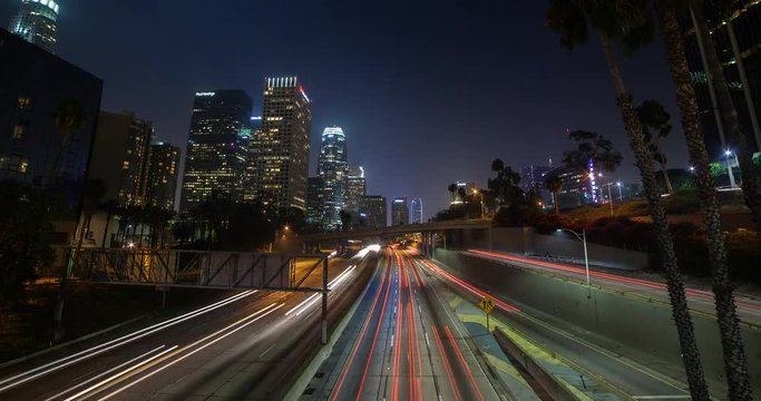Los Angeles, California, USA - Light trails of passing cars at Freeway 110 - view from Bridge 3rd St. at Financial District facing southwest at night - Timelapse with zoom out 
