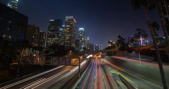 Los Angeles, California, USA - Light trails of passing cars at Freeway 110 - view from Bridge 3rd St. at Financial District facing southwest at night - Timelapse with pan left to right