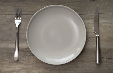Empty ceramic plate on a wooden table.