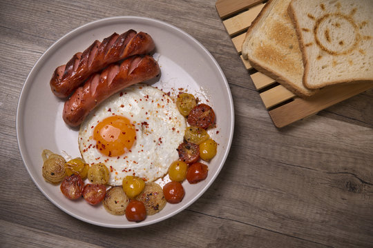 Scrambled eggs with sausages, tomatoes cherry and onion