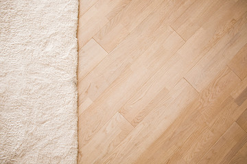 Laminate parquete floor with beige soft carpet