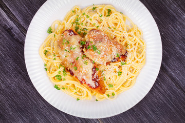 Chicken parmesan and pasta. Chicken breasts and spaghetti. View from above, top studio shot