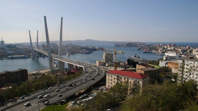 Modern bridge of city of Vladivostok. Timelapse top view Bridge over the sea Bay "Golden horn". Russian new bridge built to the Summit. Business life of the port city.