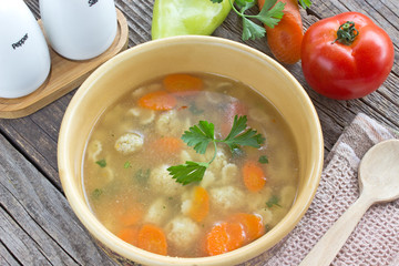 Soup with meatballs and vegetables in ceramic bowl