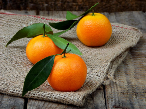 three ripe tangerine on a wooden background. selective focus.
