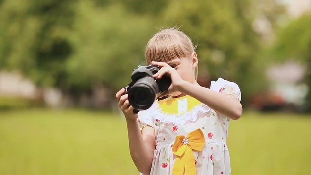 Teen girl making photo using the camera outdoors in the summer.