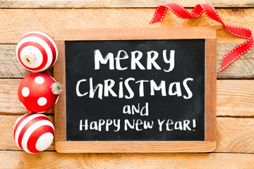 Christmas decoration with merry christmas on blackboard over wooden background © roobcio