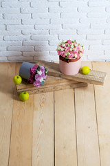 flowers and apple on wooden planks
